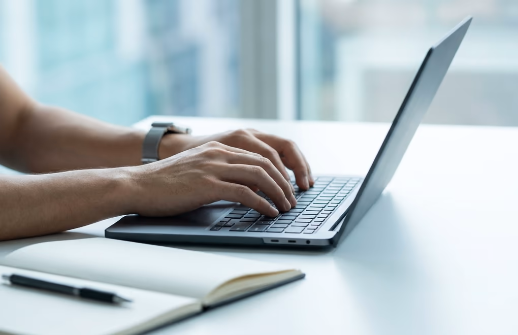 Hands typing a concise, optimized LinkedIn headline on a laptop