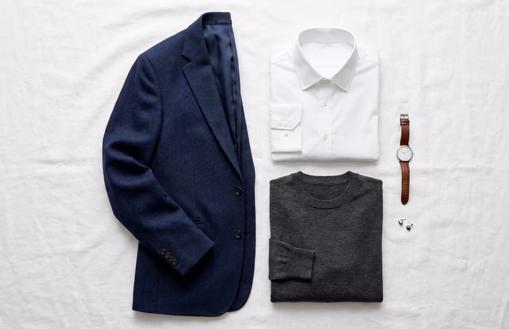 Professional blazer and collared shirt on a hanger against neutral wall