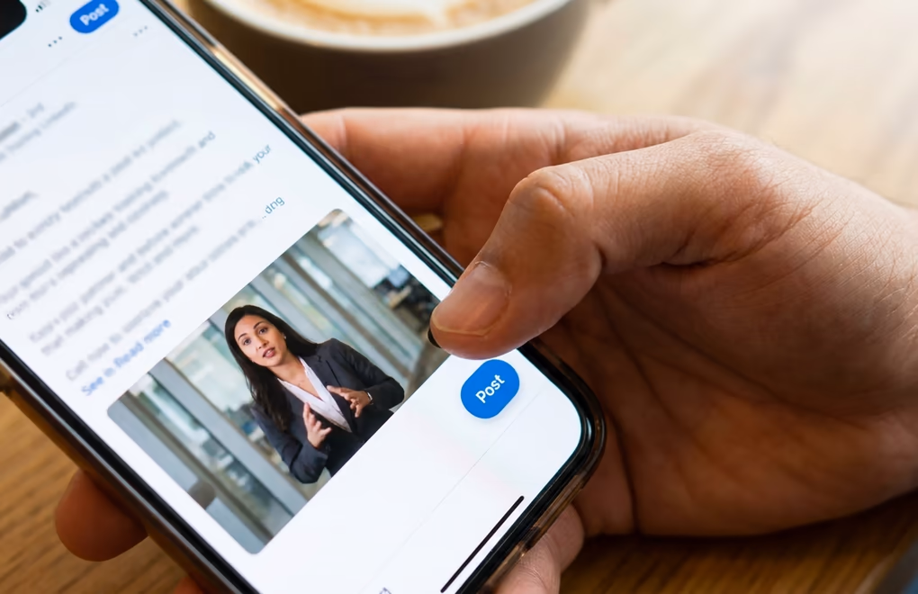 Finger tapping the blue Post button on LinkedIn mobile app with a video preview